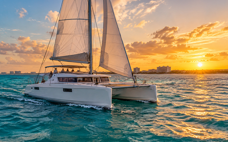 Catamaran sailing off the coast of Cancun at sunset