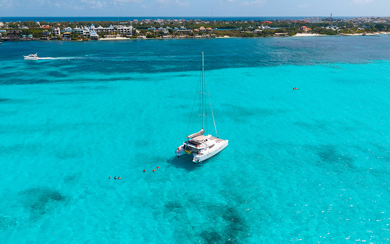 Catamarán privado navegando de Cancún a Isla Mujeres con vistas al mar Caribe y aguas cristalinas
