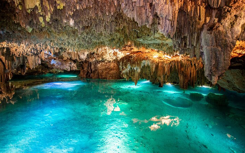 Visitantes practicando snorkel en las aguas cristalinas del cenote Yal-Kú en la Riviera Maya