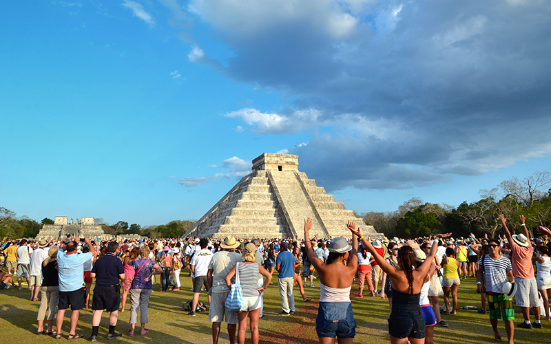 Visitantes observando el descenso de Kukulcán en Chichén Itzá durante el equinoccio.
